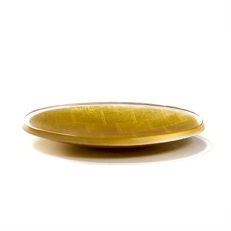 Low side view of a round gold mosaic platter